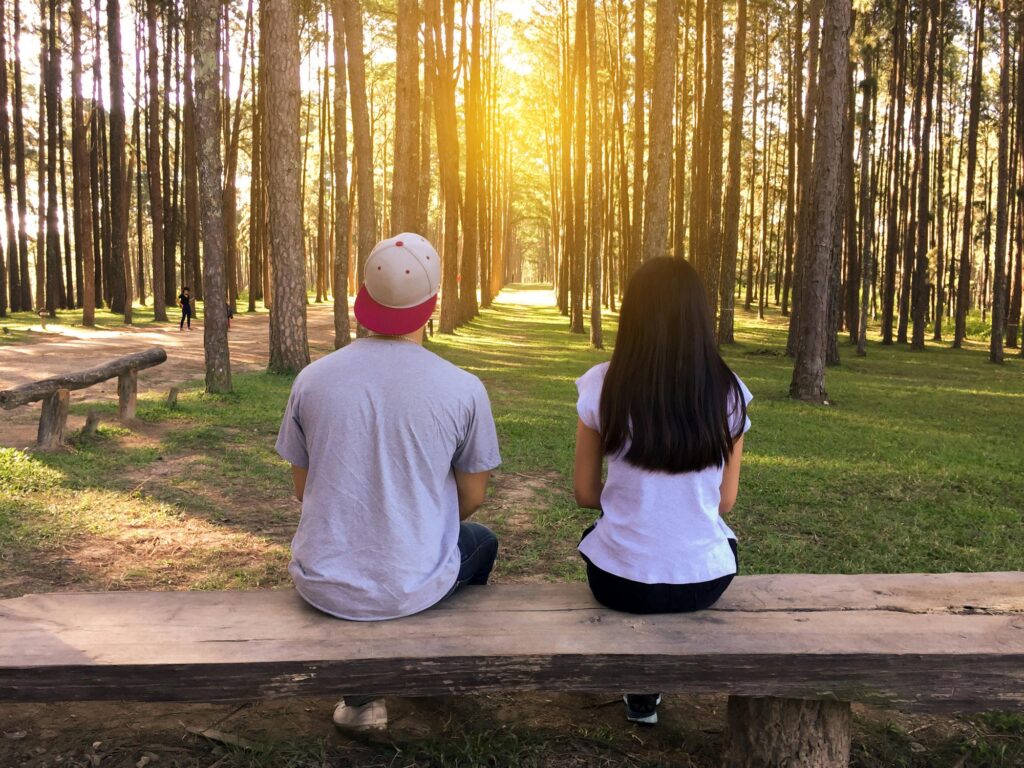 A Couple sitting near the woods